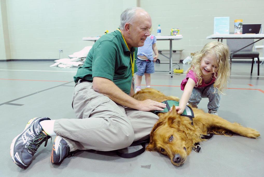 Picture of little girl petting comfort dog in texas shelter after flooding.jpg